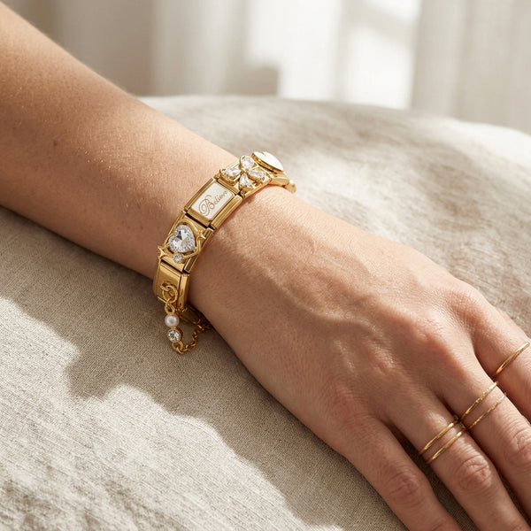 Gold 9mm Italian charm bracelet with gemstones on a wrist against a neutral background