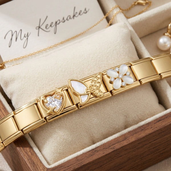 Gold 9mm Italian charm bracelet with heart butterfly and floral designs on a cushioned surface with 'My Keepsakes' text.