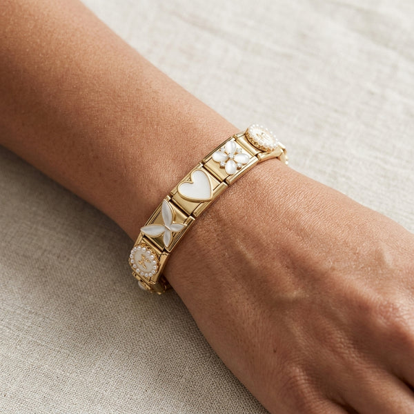 Gold 9mm Italian charm bracelet with heart and butterfly designs on a wrist against a neutral background