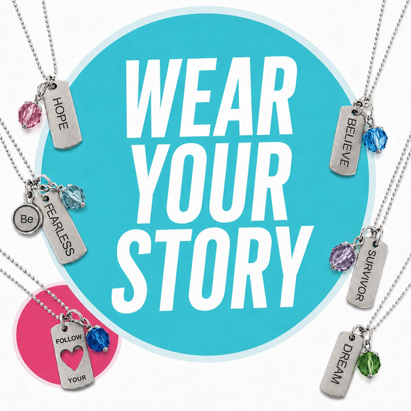 Silver dog tag necklaces with colorful beads on ball chains arranged with WEAR YOUR STORY round teal and pink logo on white background. Tags say Hope, Be Fearless, Follow Your Heart, Dream, Survivor, Believe.