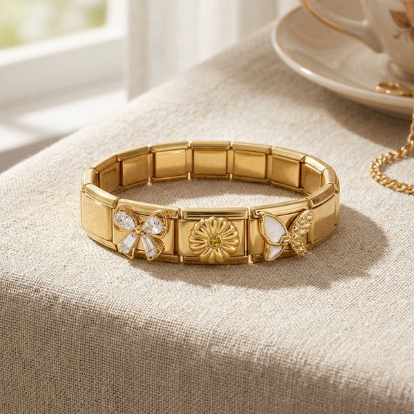 Gold 9mm Italian charm bracelet with floral design and citrine stone, elegant bow with baguette and teardrop shaped crystals on a beige surface