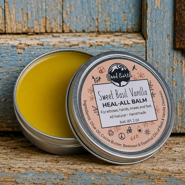 Open 2 oz tin of Good Earth Soap Co. Sweet Basil Vanilla Heal All Balm showing the natural balm inside on a rustic wooden background.