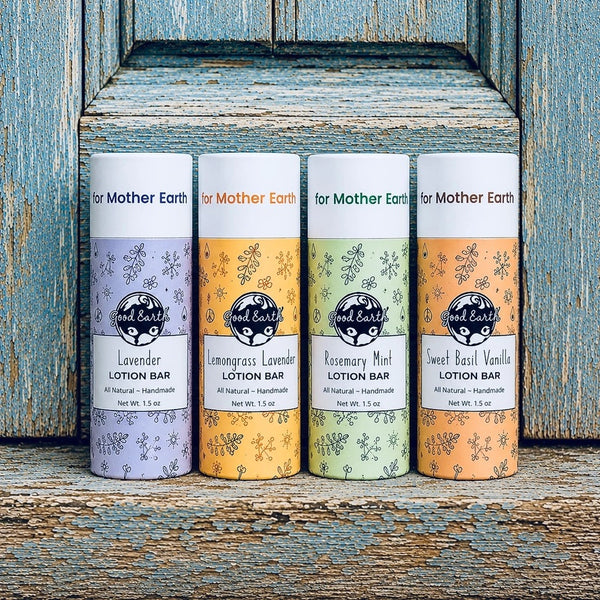 Four Good Earth Soap Co. 1.5 oz Lotion Bars in Lavender, Lemongrass Lavender, Rosemary Mint, and Sweet Basil Vanilla displayed on a rustic blue wooden shelf.