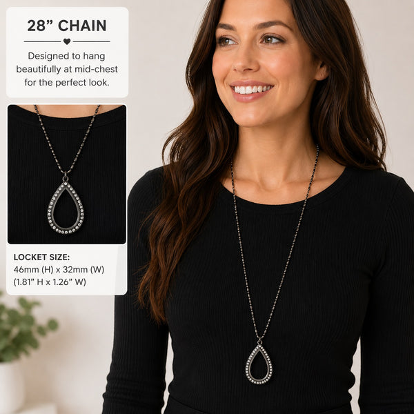 A woman wearing a long silver teardrop floating charm locket necklace with a rhinestone-studded drop, shown against a light neutral background. The image includes informational text boxes detailing the 28-inch chain length and locket size.