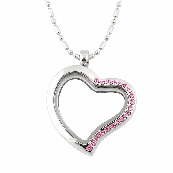 A silver-toned heart shaped floating charm locket heart necklace adorned with a row of small pink rhinestones along one edge, suspended from a matching silver ball chain against a plain white background.