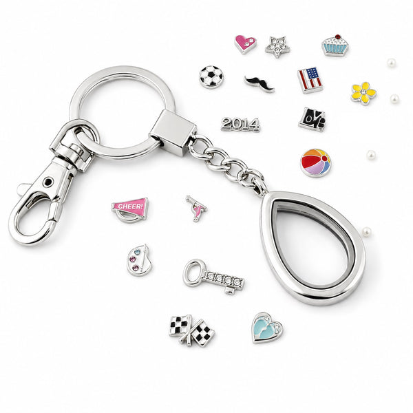 Silver Teardrop Floating Charm Locket Keychain With Assorted Charms Scattered On White Background