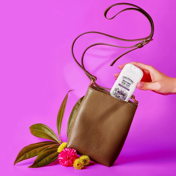 Poo Pourri TSA Approved Pocket Sprayer Toilet Spray In Brown Purse On Purple Background