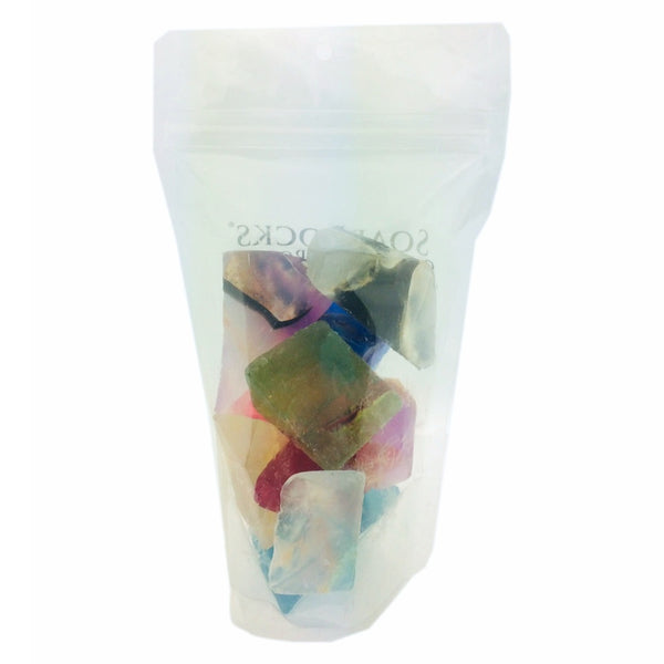 Clear plastic bag with colorful soap that looks like real gemstones inside on a white background