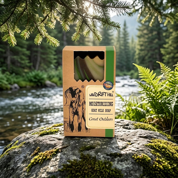 Box of Windrift Hill soap on a rock with a river and forest background