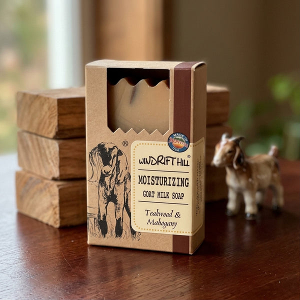 Box of Windrift Hill moisturizing goat milk soap on a wooden surface with a goat figurine and blurred background